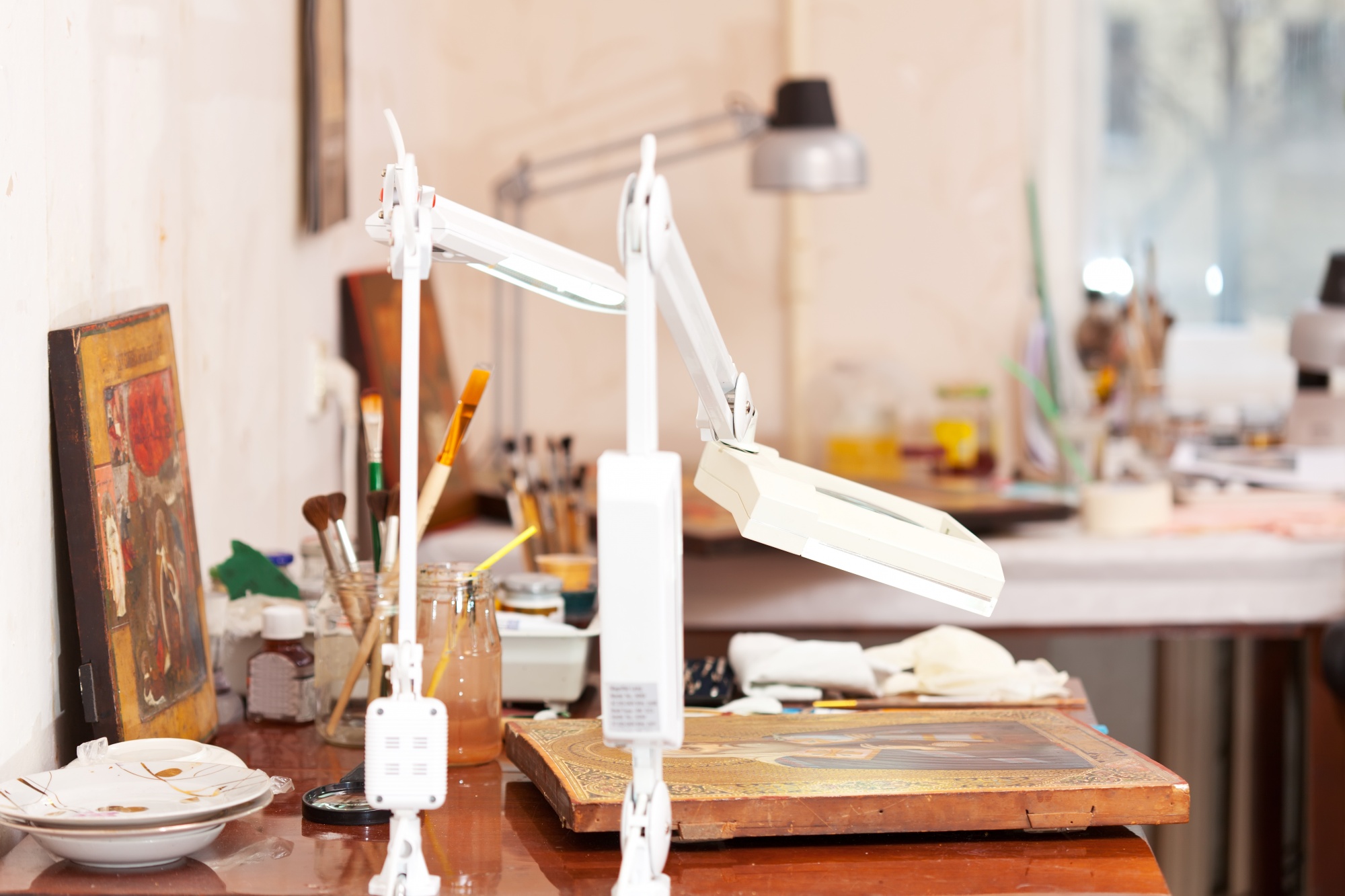 Interno dell'atelier con tavoli e luci calde